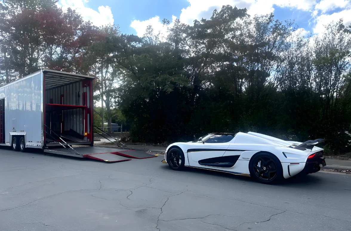 High-end vehicle being loaded into an enclosed transport trailer
