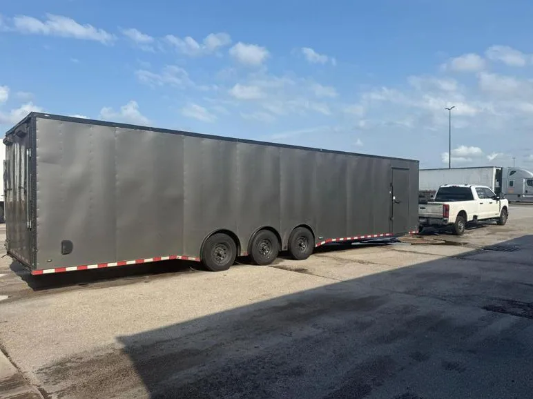 Motorcycle shipping with secure wheel chocks and soft-tie strapping on enclosed trailer