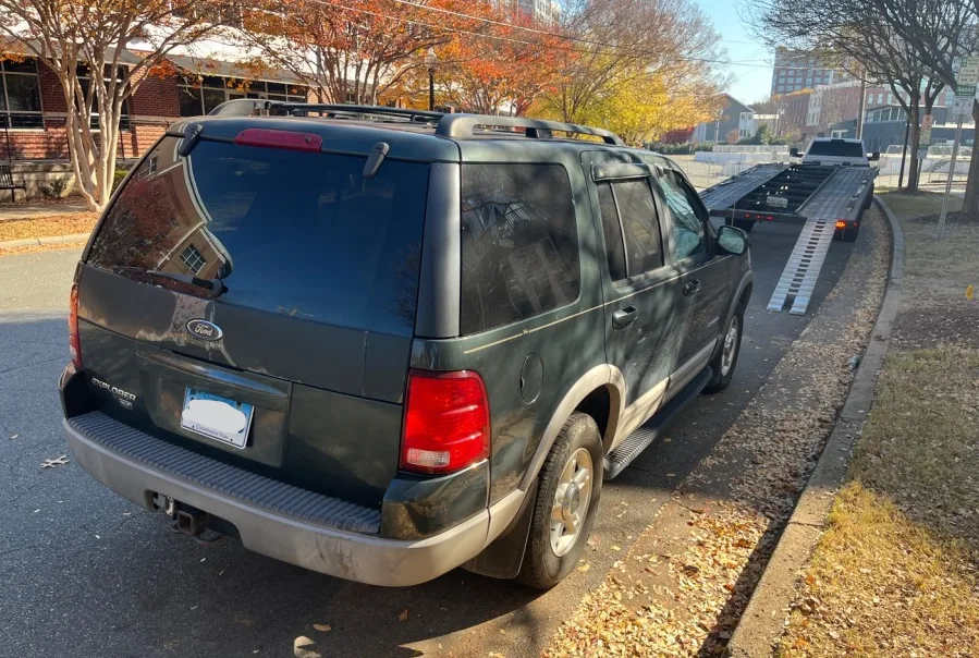 Vehicles secured on open carrier with professional tie-down strapping
