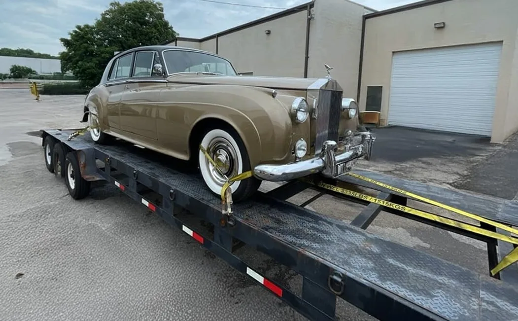 Vehicle being loaded onto an open transport carrier